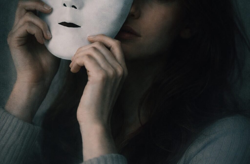 A woman putting on a mask representing the moment before pretending everything is fine in a relationship